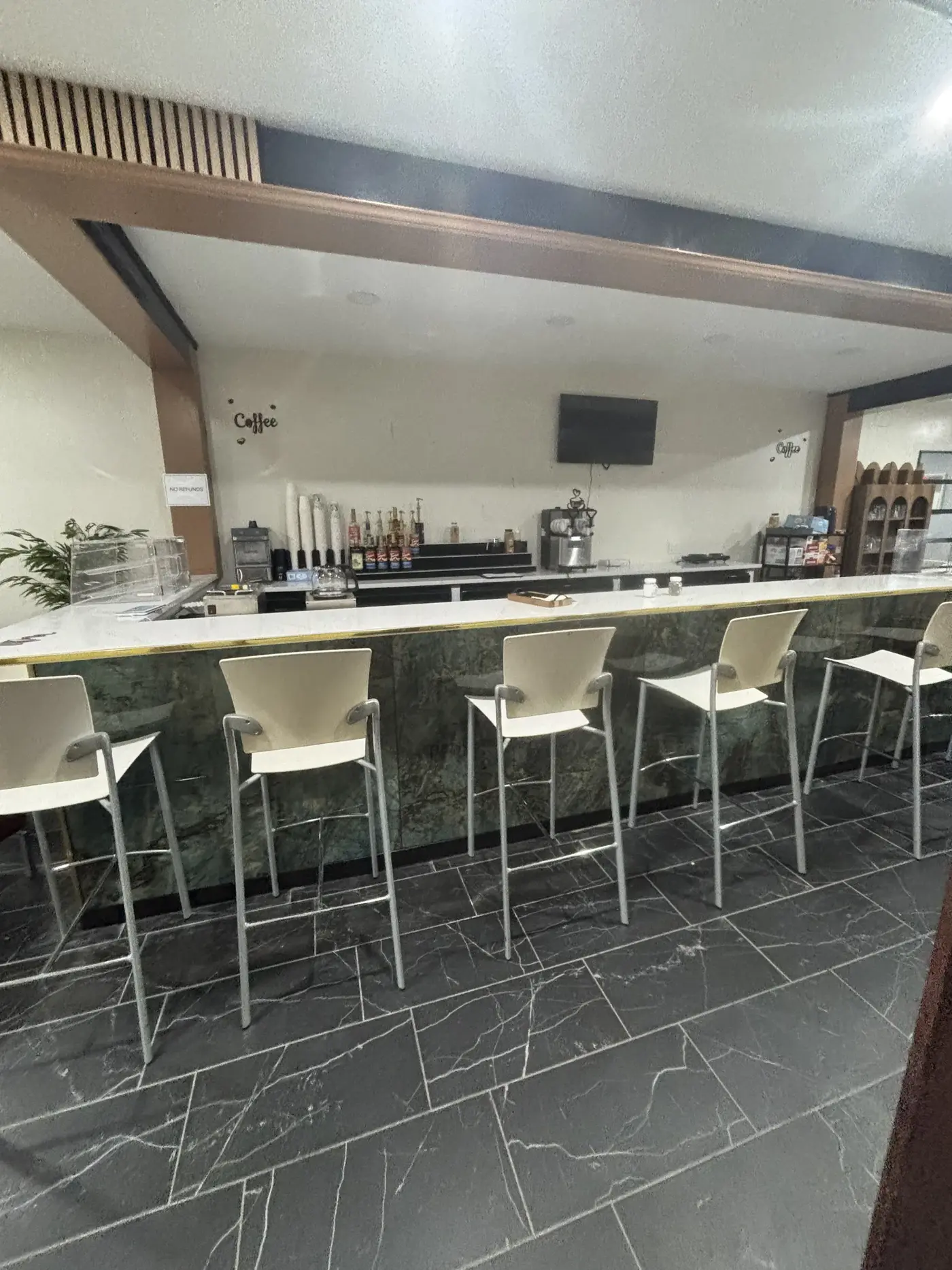 Bar stools lined up along Oak's green marble bar